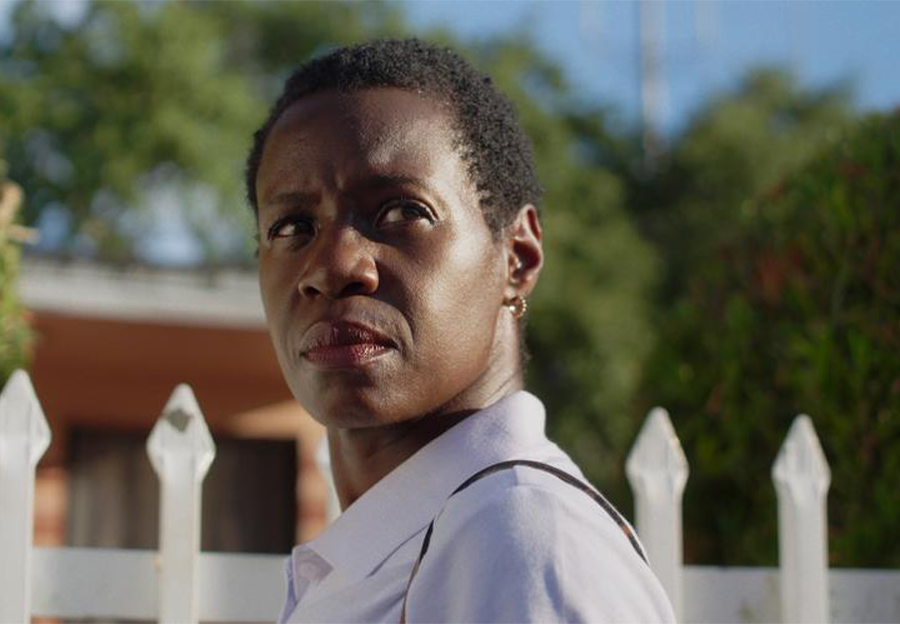 Woman staring at you with fence in background