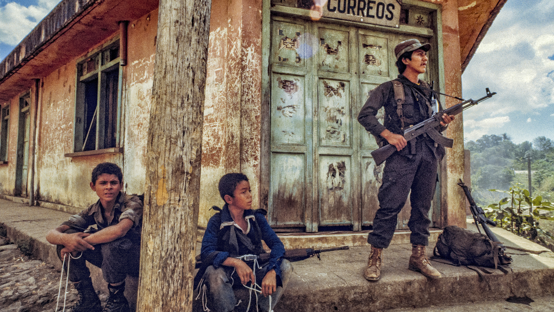 men with guns standing in front of a building