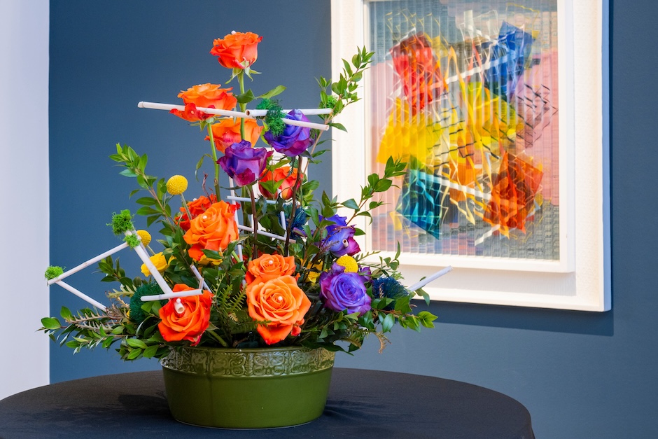 flowers on a table in front of a contemporary artwork