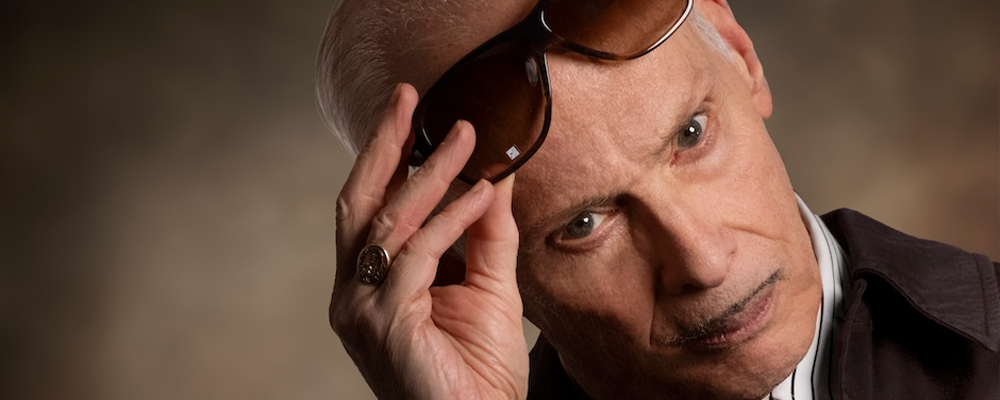 The legendary one and only john waters staring into your soul as he takes off his glasses